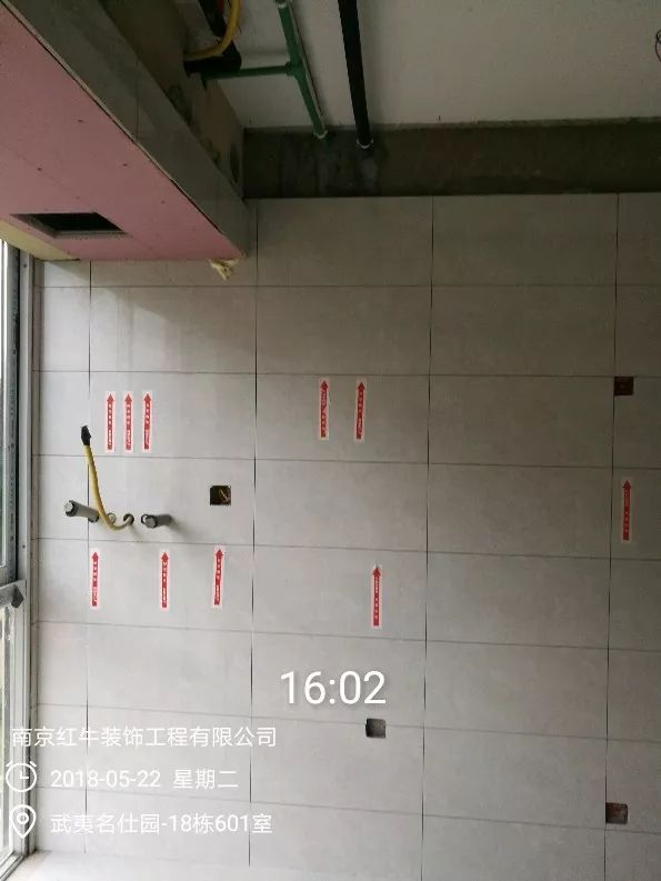 南京武夷名仕園124平米簡(jiǎn)美風(fēng)格裝修  享受家?guī)?lái)的溫度30五月份_墻磚鋪貼完成后，紅牛裝飾的工人會(huì)用專(zhuān)用護(hù)角條對(duì)瓷磚角保護(hù)，用標(biāo)貼標(biāo)出水管、線管走向示意。